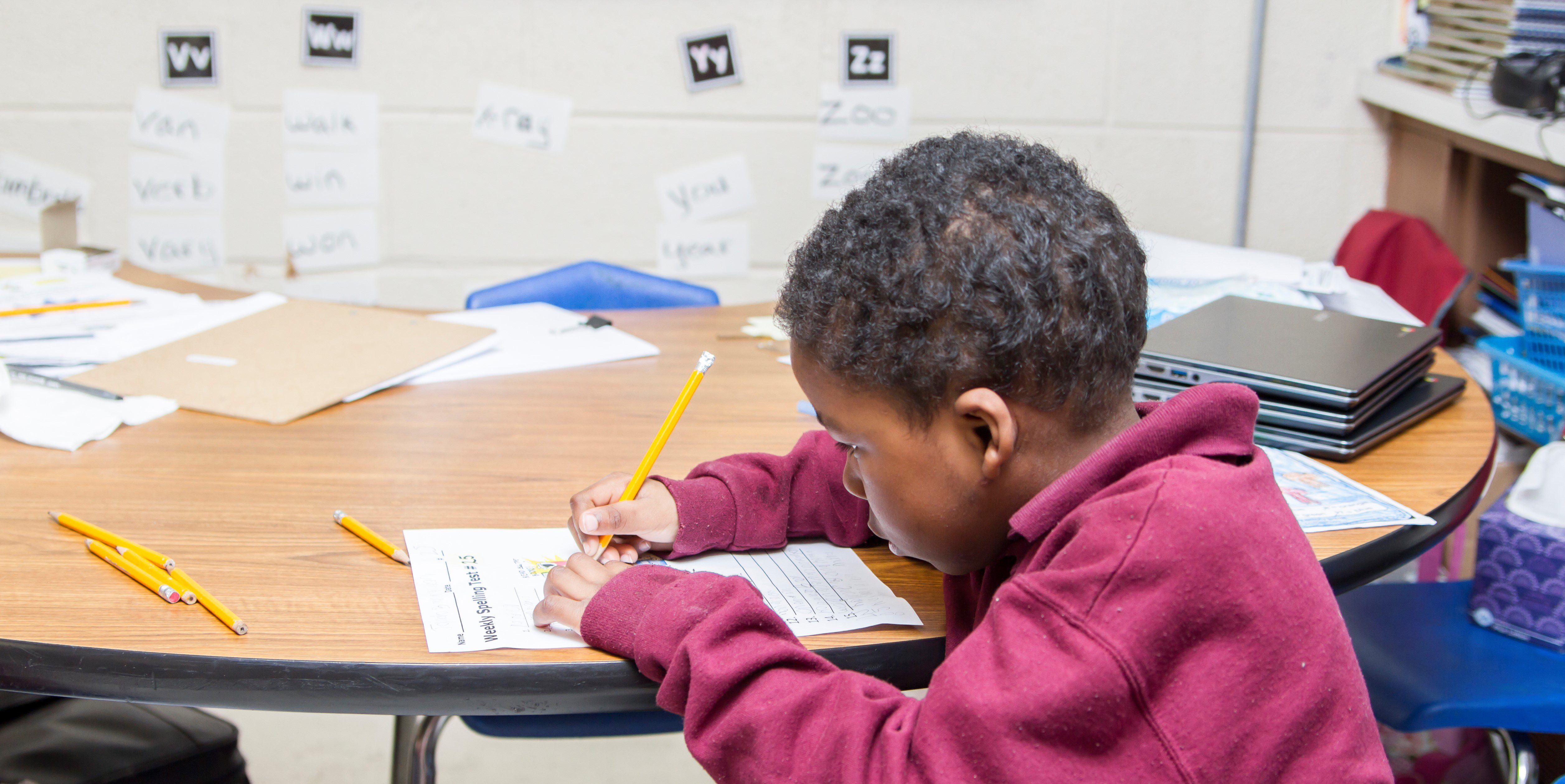 Child working at desk in classroom.