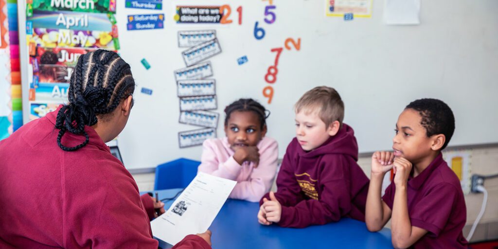 A group of students is listening to the teacher read.